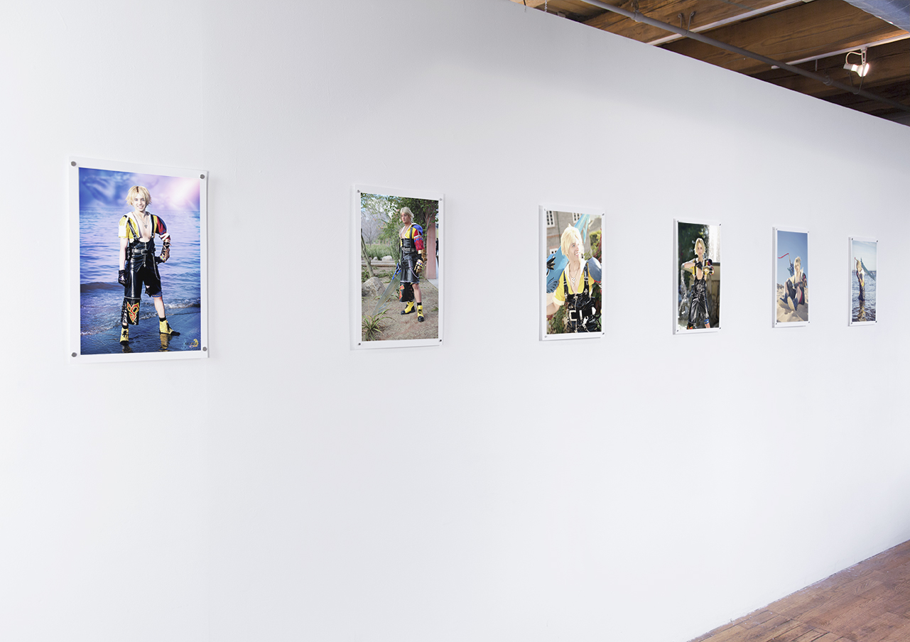 Six small prints hung on a white wall